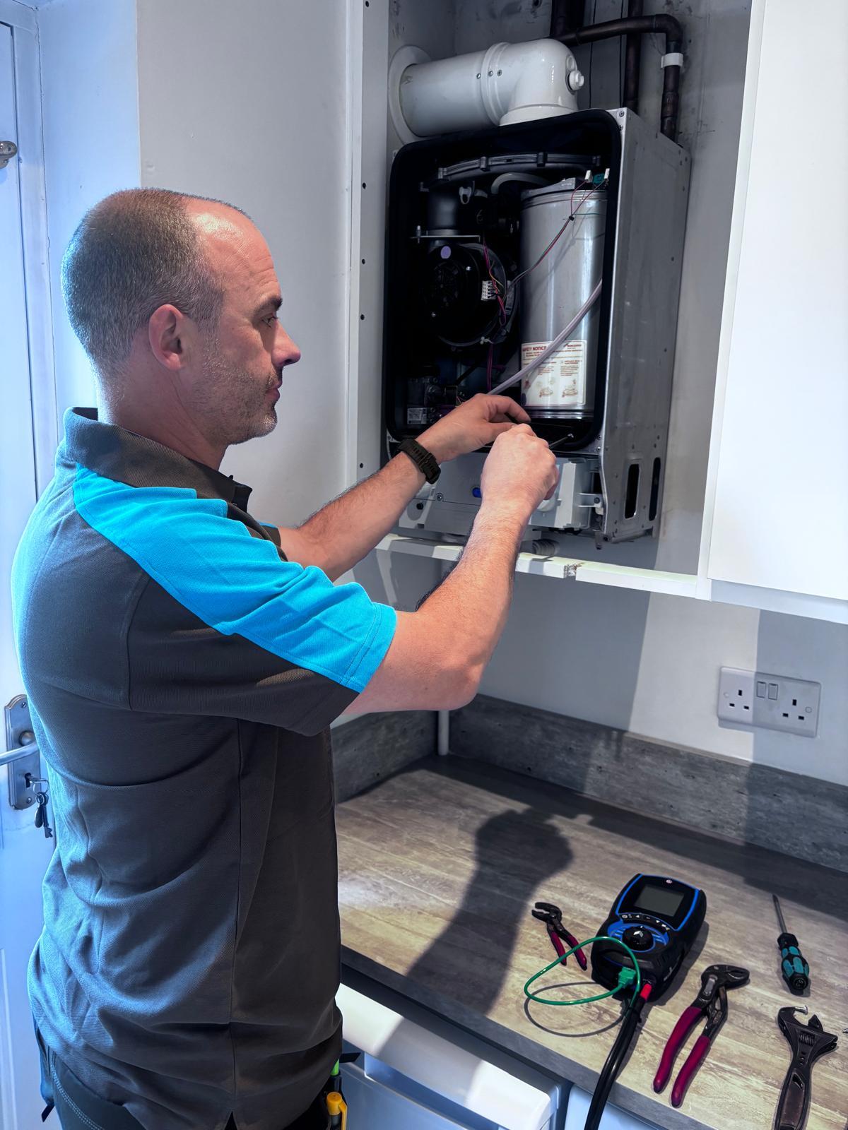 Matt servicing a Worcester combi boiler with combustion analyser and tools